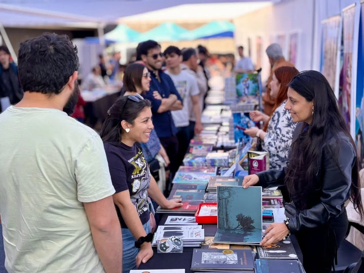 Lectoras conversando con una editora en su stand